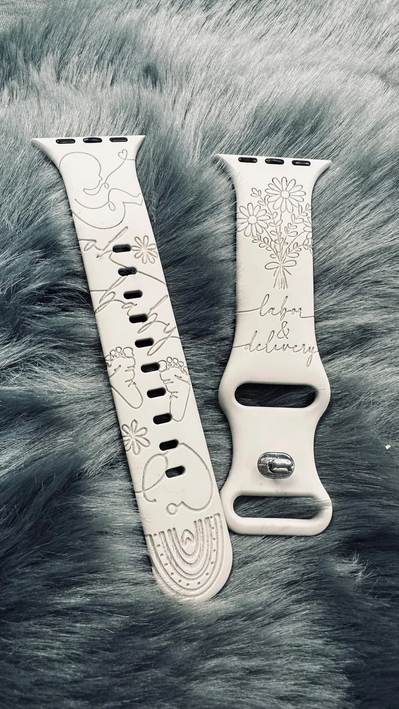 Cream engraved watch band with line-art of a mother and baby, tiny feet and the words labor and delivery.